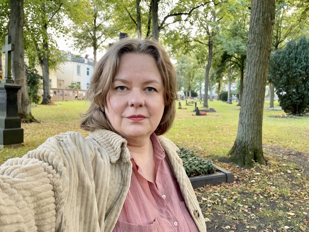 Bettina Steinhage sitzt auf einem Friedhof und denkt über die Richtung im Leben nach.